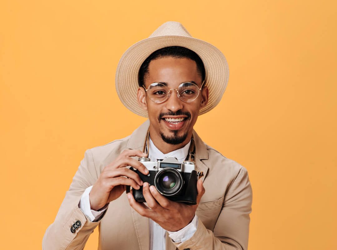 black-man-in-hat-and-glasses-holding-retro-camera-2021-09-03-01-24-36-utc-e1661912402101.jpg